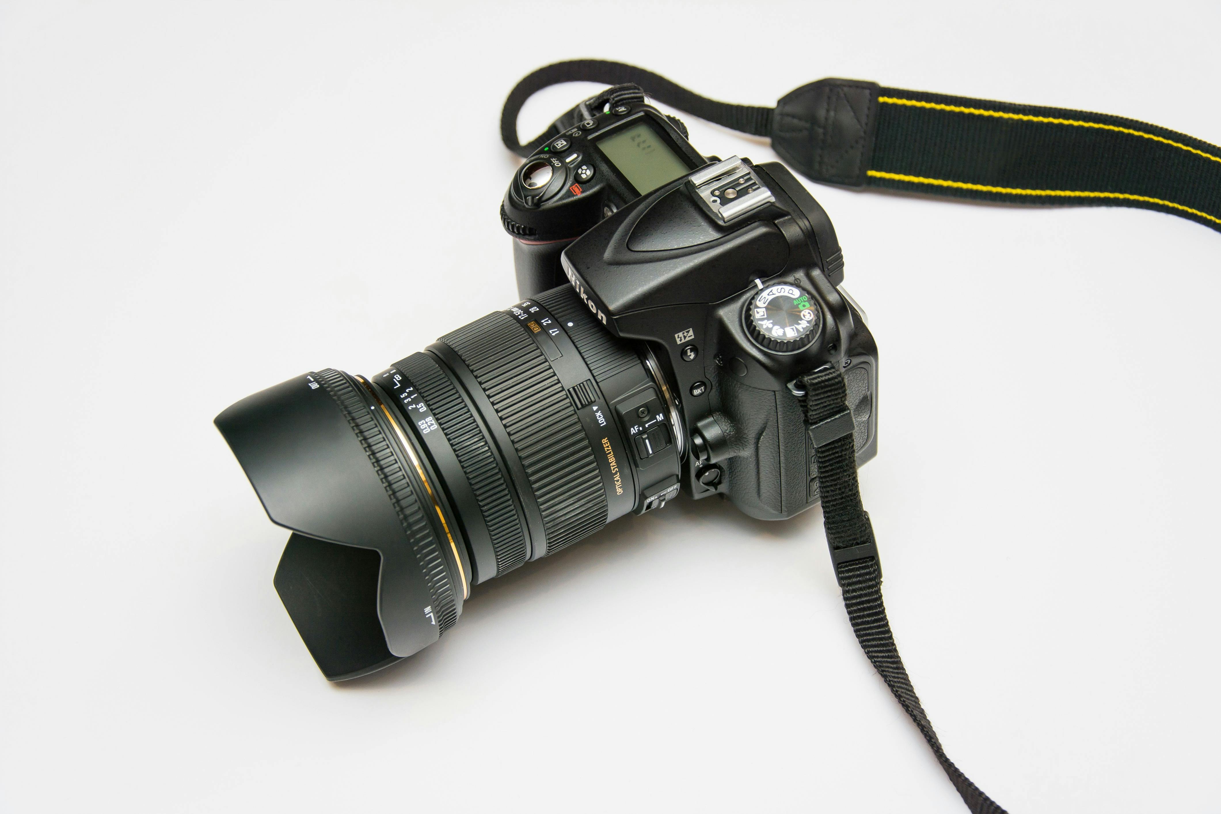 Close-up of a DSLR camera with a lens and strap, ideal for photography equipment themes.